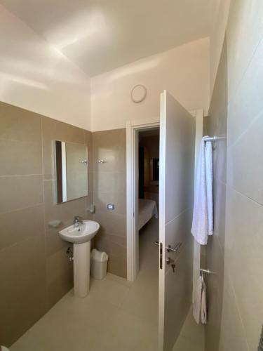 a bathroom with a sink and a toilet and a mirror at Blu Horizon Hotel Gjipe in Dhërmi