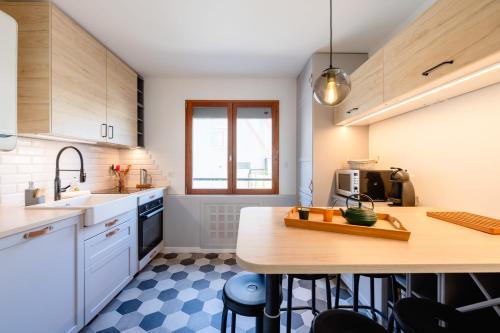 una cocina con armarios blancos y una mesa con sillas. en Les Hirondelles - Appartement 3 chambres à Annecy, en Annecy