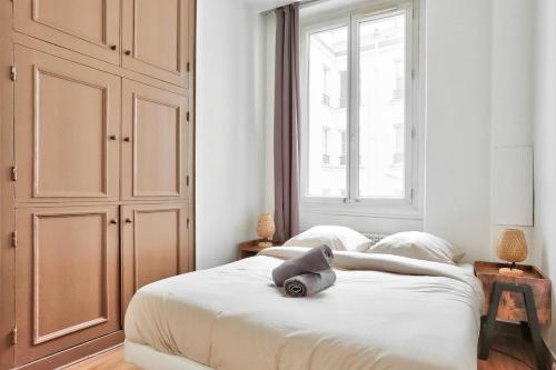 a bedroom with a bed with a hat on it at Appartement Quartier Champs-Élysées in Paris