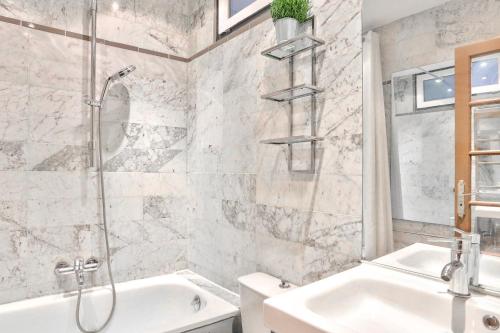 a bathroom with a shower and a tub and a sink at Appartement Quartier Champs-Élysées in Paris