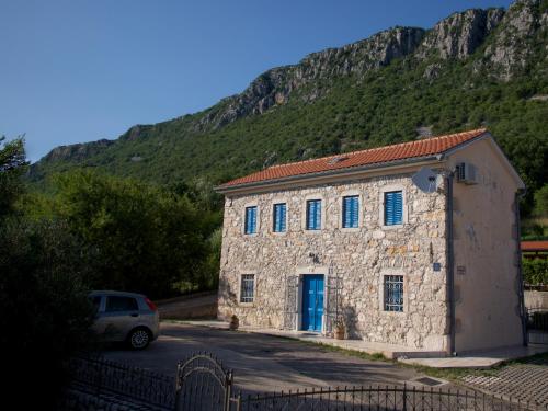 a stone building with a car parked in front of a mountain at Ferienhaus Katarina in Bribir