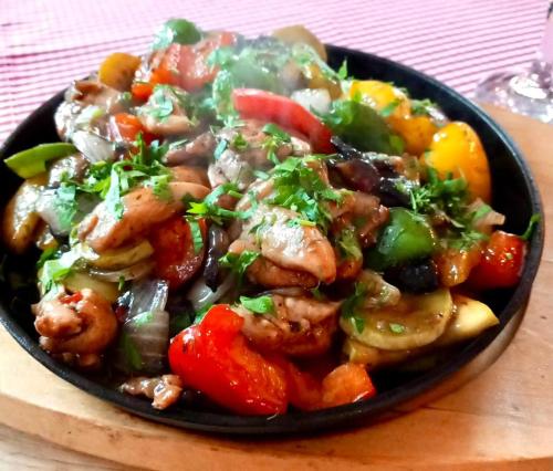 a bowl of food with shrimp and vegetables on a table at Blumenhof Bucovina in Voronet