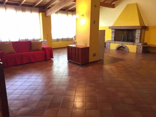 a living room with a red couch and a fireplace at Foresto Case Vacanza in Volta Mantovana