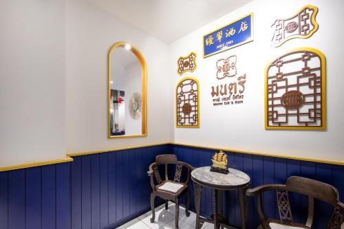 a blue and white room with a table and chairs at Montree Phuket Hotel in Phuket Town