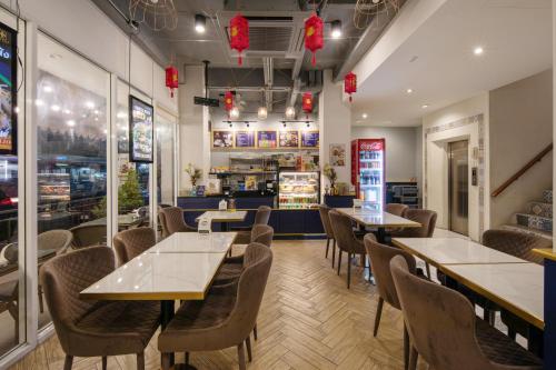 a restaurant with tables and chairs and a counter at Montree Phuket Hotel in Phuket Town