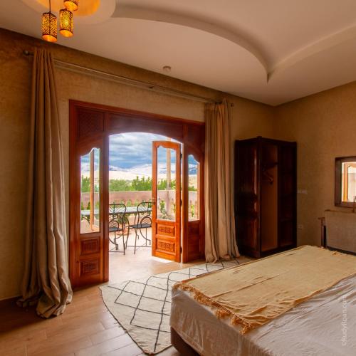 a bedroom with a bed and a balcony at Les terrasses du Lac Marrakech in Lalla Takerkoust