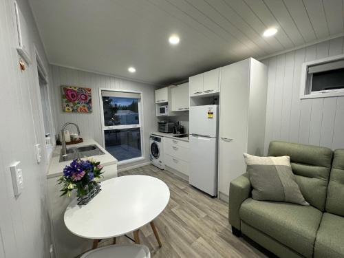 a small living room with a table and a couch at BENROSE FARM COTTAGES in Wellington