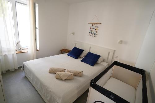 a bedroom with a bed with blue pillows and a chair at ELEVEN in Šibenik
