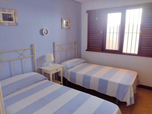 a bedroom with two beds and a window at Nogalera con piscina in Torremolinos