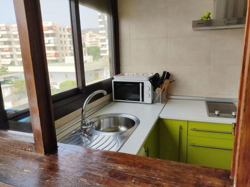 a kitchen with a sink and a microwave at Nogalera con piscina in Torremolinos