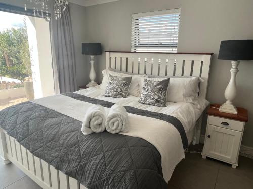 a bedroom with a large bed with towels on it at Langebaan Luxury Room in Langebaan