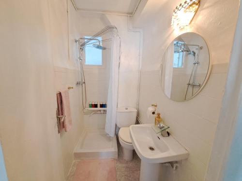 ein Badezimmer mit einem Waschbecken, einem WC und einem Spiegel in der Unterkunft Apartamento acogedor con wifi in Valencia