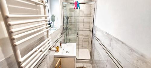 a small bathroom with a sink and a shower at Apartament Noniewicza Centrum in Suwałki