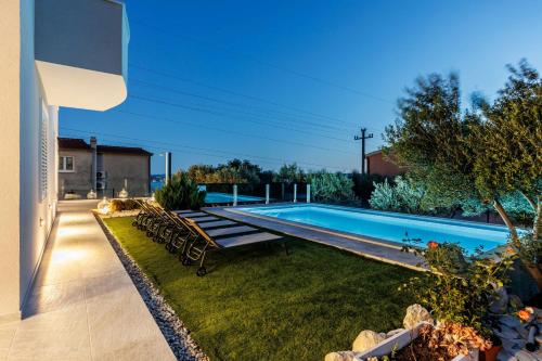 uma piscina no quintal de uma casa em Villa Dalmatina Hill House - private pool, sea and hill view, rooftop terrace, free parking em Kaštela