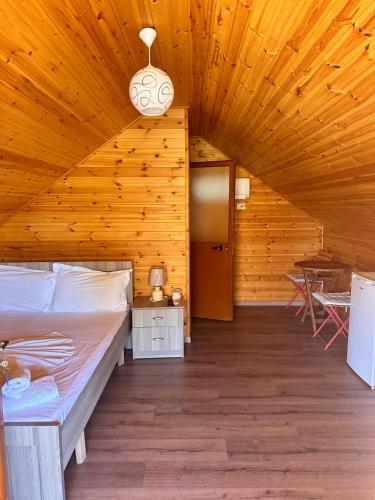una camera con letto e soffitto in legno di Boi Villas a Dhërmi