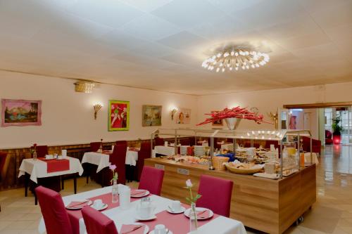 ケルンにあるホテル エスプラナーデのテーブルと椅子のあるレストラン、ビュッフェ