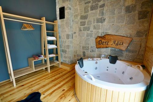 uma banheira num quarto com uma parede de pedra em DERE AĞZI TATİL KÖYÜ em Rize