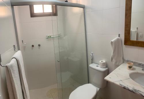a bathroom with a shower and a toilet and a sink at Jardim Secreto - Itaipava in Itaipava