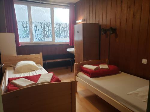 ein kleines Zimmer mit 2 Betten und einem Fenster in der Unterkunft Hébergement Artense in Le Mont-Dore