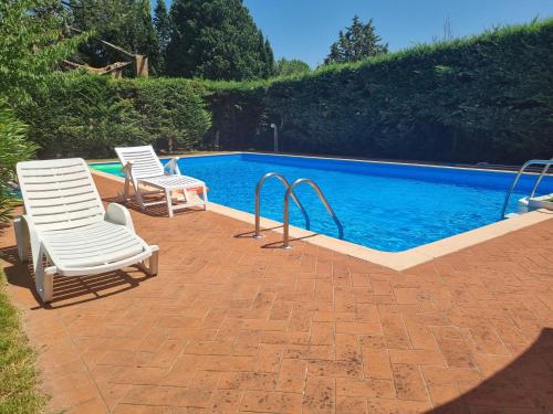 duas cadeiras sentadas ao lado de uma piscina em Gli ulivi di Siena em Siena