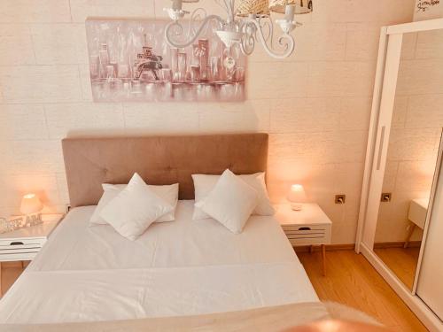ein Schlafzimmer mit einem weißen Bett mit zwei Kissen in der Unterkunft Vanja in Čukarica