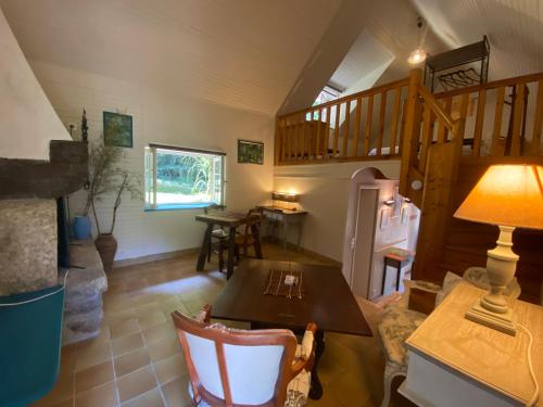 een woonkamer met een tafel en een trap bij ÉCO-VILLAGE Les Moulins du Duc in Moëlan-sur-Mer