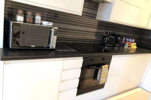 a kitchen counter with a microwave and a stove at Smithfield St Paul Farringdon Central London Apartment in London