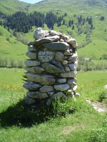 a stone wall with a sign on it in a field at Isov Ranch in Plav