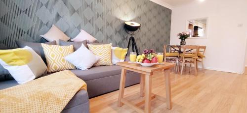 2 Single Beds, 1 BR Apartment في نيوماركت: غرفة معيشة مع أريكة وطاولة