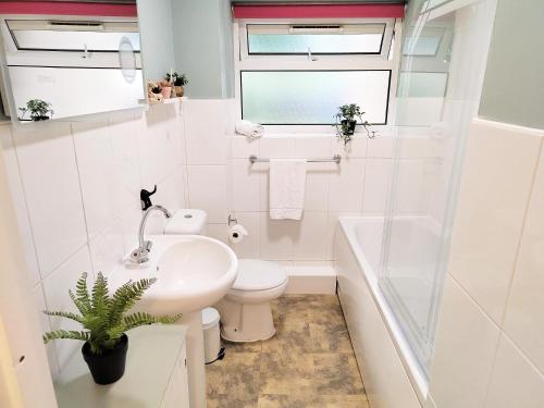 2 Single Beds, 1 BR Apartment في نيوماركت: حمام أبيض مع حوض ومرحاض