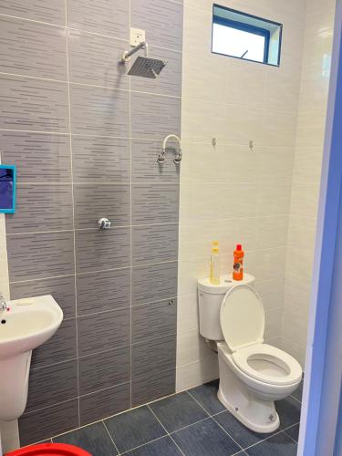 ein Bad mit einem WC und einem Waschbecken in der Unterkunft Aimy’s Homestay in Simpang Empat
