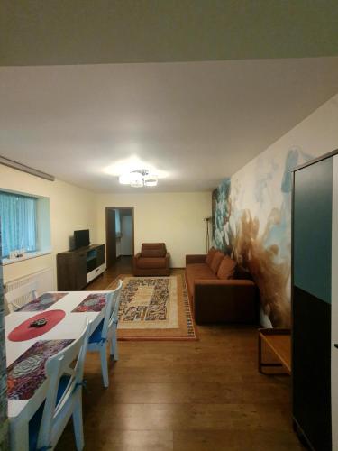 een woonkamer met een tafel en een bank bij Forest Apartments in Sinaia