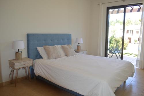 une chambre avec un grand lit et une tête de lit bleue dans l'établissement Luxury 1-Bedroom Apartment Alvor Duo Village, à Alvor