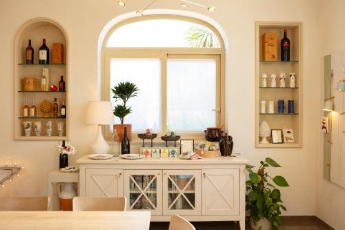 a room with a large window and a counter with bottles at Borgo Mulino a Vento - Resort in Uggiano la Chiesa