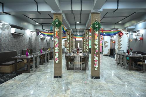 ein Restaurant mit Tischen und Stühlen und farbenfroher Dekoration in der Unterkunft Hotel M K Plaza in Bodh Gaya