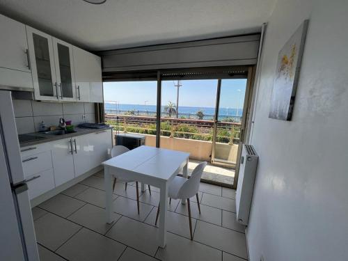 eine Küche mit einem Tisch und Meerblick in der Unterkunft Licorne G14 in Cannes