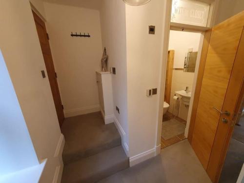 un pasillo con una escalera que conduce a un baño en Cosy, Central Apartment Skipton, en Skipton