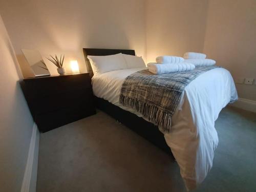 1 dormitorio con 1 cama con sábanas y almohadas blancas en Cosy, Central Apartment Skipton, en Skipton