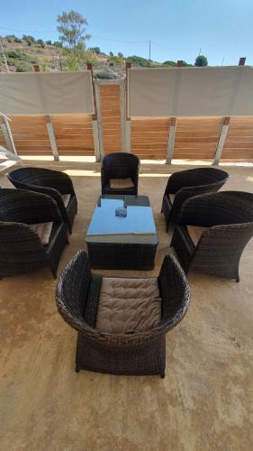 a patio with wicker chairs and a table and a table and chairs at AQUA VILLA in Selínia