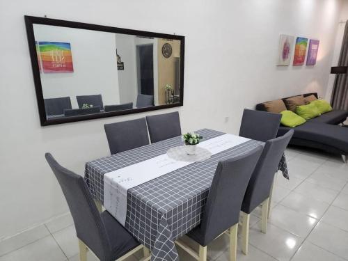 a dining room table with chairs and a mirror at Hud D'Lipis Homestay in Kuala Lipis