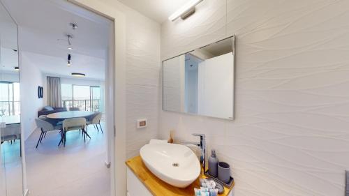 ein weißes Badezimmer mit einem Waschbecken und einem Spiegel in der Unterkunft Savyon V.I.E.W- Gorgeous Jerusalem views! Rental Israel in Jerusalem