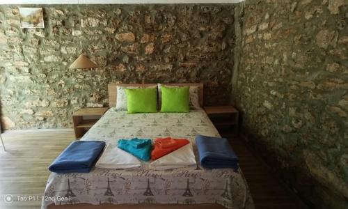 een slaapkamer met een bed met groene en blauwe kussens bij Граничар 3 СЪРФА in Granichar