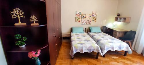 a bedroom with two beds and a desk and a table at ZeusPlace Litochoro Central Traditional House in Litochoro