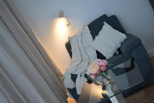 K - Town Hotel في كاثرين: غرفة معيشة مع أريكة مع إناء من الزهور