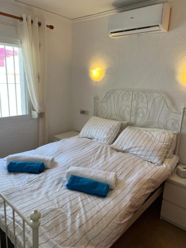 Una cama blanca con dos almohadas azules. en Luces Del Mar Beautiful bungalow with seaview near to Moraira en Benitachell