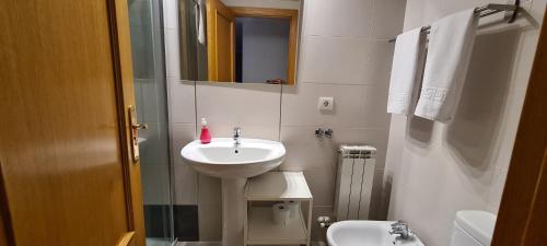 a small bathroom with a sink and a toilet at NUEVO LLANO JOB&FAMILY in Puebla de Alfindén