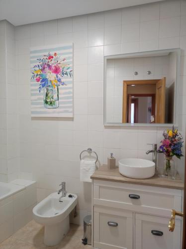 a bathroom with a sink and a toilet and a mirror at La Casa del Valle 2 in Soncillo