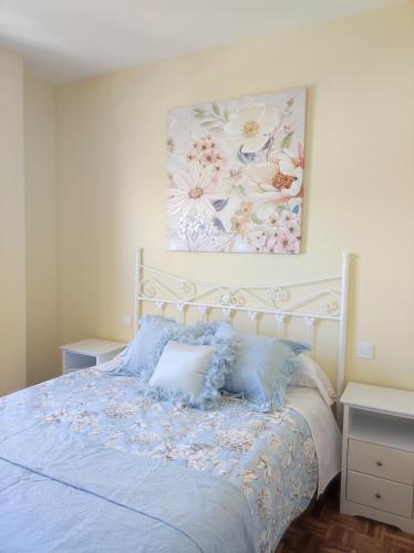 a bedroom with a bed with a painting on the wall at La Casa del Valle 2 in Soncillo