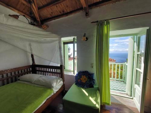 a bedroom with a bed with a view of the ocean at Elma's Houses - Green House Yanna in Alonnisos