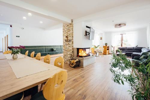 a living room with a table and a fireplace at Blumenhof Bucovina in Voronet